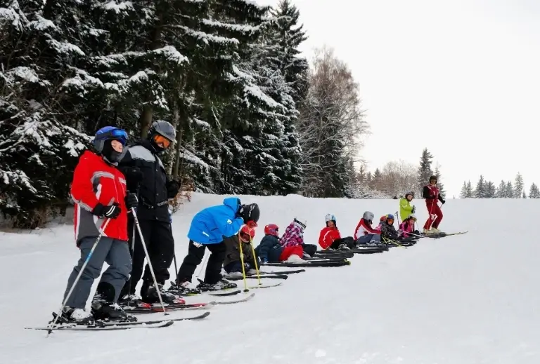 dorośli i dzieci na nartach